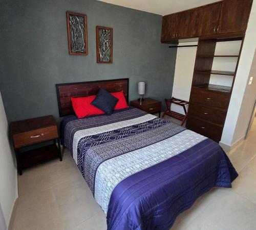 een slaapkamer met een bed met paarse lakens en rode kussens bij Casa Fray in San Miguel de Allende