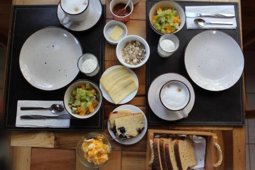 a table topped with plates and bowls of food at Hotel El Coihue in Pucón