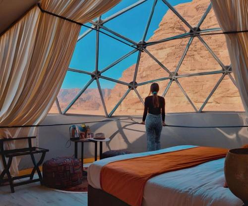 a woman standing in a room looking out at the desert at Bedouin Camp&tour in Wadi Rum