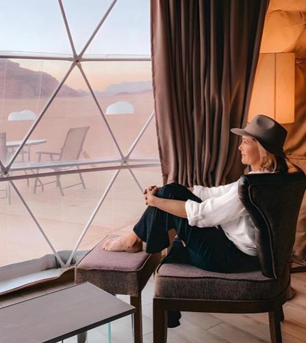 a woman sitting in a chair in front of a window at Bedouin Camp&tour in Wadi Rum