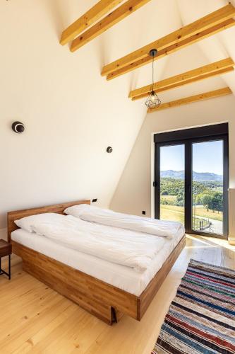 a bedroom with a large bed and a large window at Bjelašnica Lodges in Bjelašnica