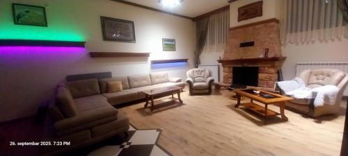 a living room with a couch and chairs and a fireplace at Vila na Rtnju in Rtanj