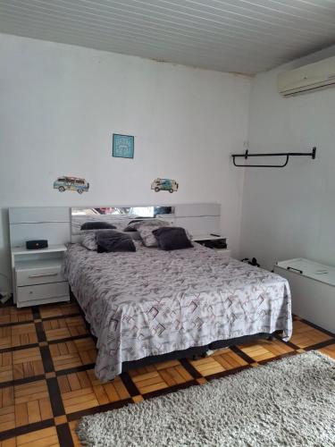 a bedroom with a large bed in a white room at Suite 1076 in Belém