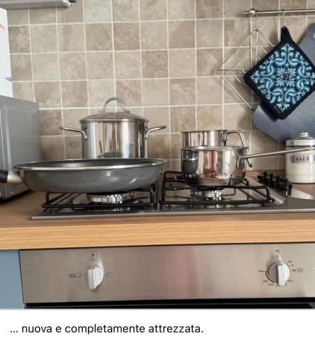 two pots and pans on a stove in a kitchen at Casa Vacanze Janas in Assemini