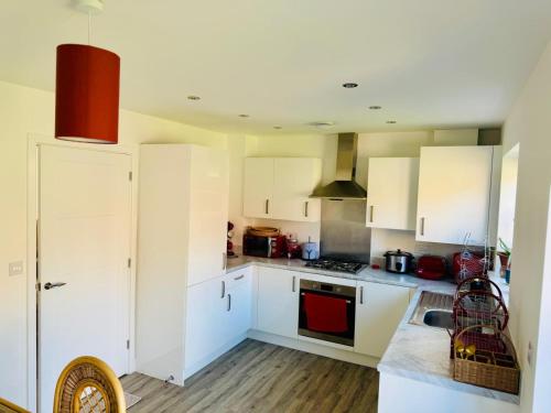 a kitchen with white cabinets and a stove top oven at Cosy Home Stay in Nottinghamshire in Retford