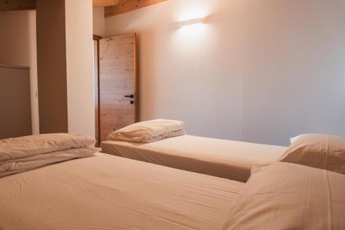 a bedroom with two beds and a closet with a door at Casa Stefania 1 in Pieve Di Ledro