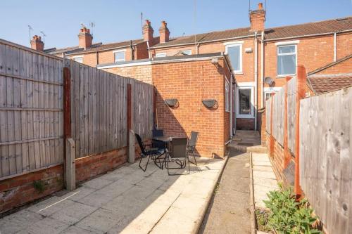 a patio with a table and chairs next to a fence at Stylish 3-Bed House near NEC HS2 and BHX Airport in Spon End