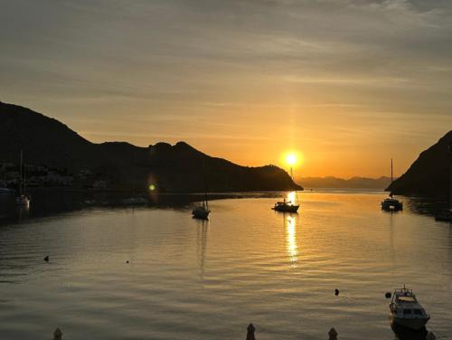 a group of boats in the water at sunset at Pedi Beach Hotel in Symi