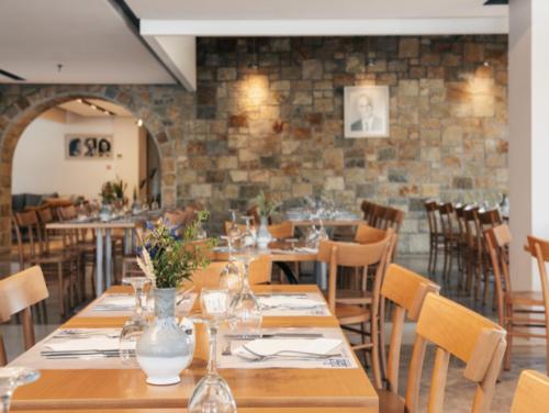 a dining room with wooden tables and chairs at Pedi Beach Hotel in Symi