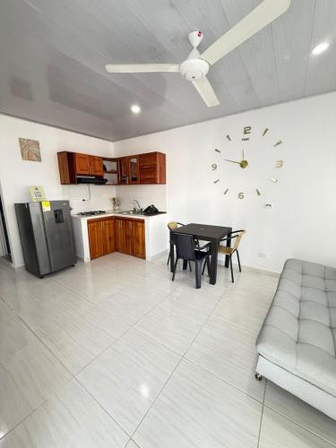 a living room with a table and a clock on the wall at TORRES DEL MESÓN LUXURY APARTA HOTEL Doradal in Doradal