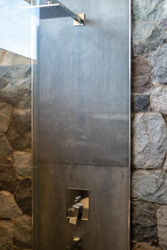 a metal shower in a stone wall at NOI Lodge Entre Viñedos in La Consulta