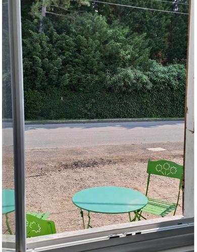 two chairs and a table outside a window at LES CERISIERS Mb4 - Mb5 - Mb6 in Damparis