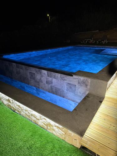 a swimming pool at night with blue water at Neto Pinto - Casa de férias / fins de semana. in Lourinhã