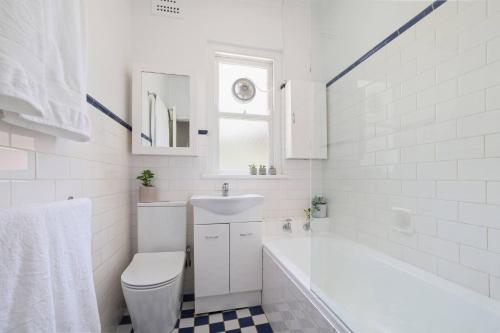 a white bathroom with a sink and a toilet at Gorgeous 3 bed 5 mins walk Shelly, Fairy Bower, Manly Beaches in Sydney