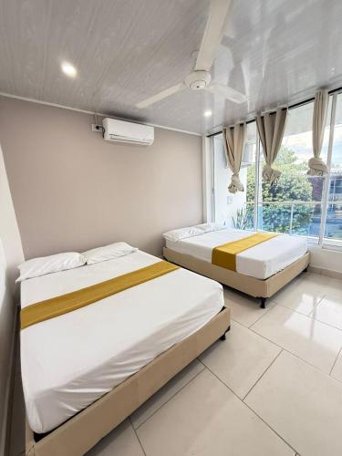 a bedroom with two beds and a window at TORRES DEL MESÓN LUXURY APARTA HOTEL Doradal in Doradal