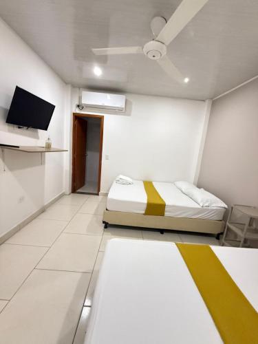 a white room with a bed and a tv at TORRES DEL MESÓN LUXURY APARTA HOTEL Doradal in Doradal
