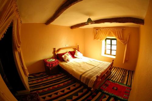 un dormitorio con una cama y una ventana en Adrar view lodge, en Imlil