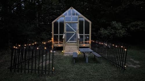 a small greenhouse in a yard at night with lights at Luxury Cozy Glamping Cabin Retreat Natural Hide Out in Sugar Hill