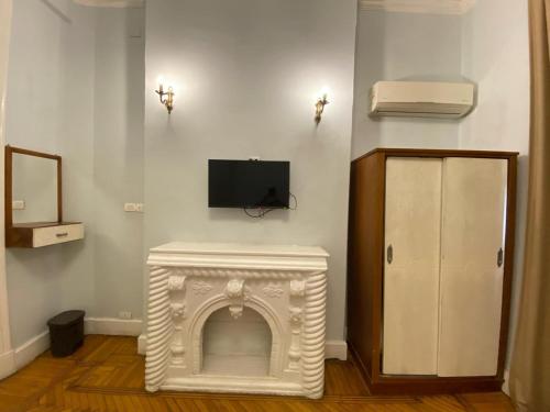 a living room with a fireplace with a tv on the wall at Cairo Nomads Hostel in Cairo