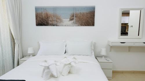 a bedroom with a white bed with white socks on it at X11 Furnished with balcony England cluster international city near Dragon Mart in Dubai