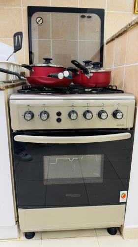 a stove with two pots and pans on top of it at X11 Furnished with balcony England cluster international city near Dragon Mart in Dubai