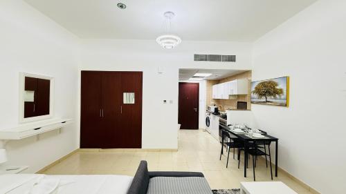 a living room with a couch and a table and a kitchen at X11 Furnished with balcony England cluster international city near Dragon Mart in Dubai