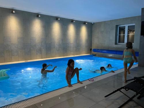 a group of people in a swimming pool at Apartmány Hluchá Bašta s vnitřním bazénem in České Budějovice
