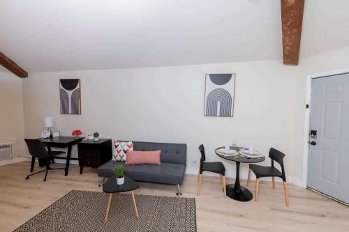 Una sala de estar con un sofá, una mesa y sillas. en King Bed Modern Studio Apartment, en Huntsville