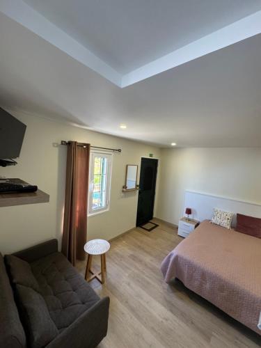 a bedroom with a bed and a couch at A Toca in Santana