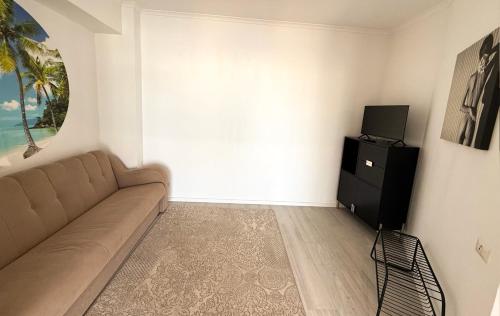 a living room with a couch and a television at Maritimo ApartHotel in Constanţa