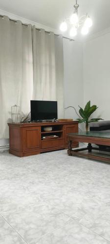 a living room with a television and a table at Le Havre de joie in Alger