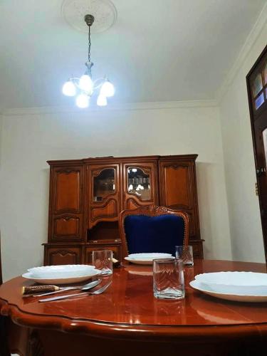 a wooden table with plates and glasses on top of it at Le Havre de joie in Alger