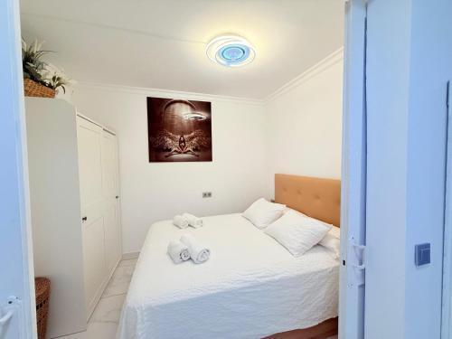 a bedroom with a white bed with towels on it at Sea view Nice apartament in Ocean View in Adeje