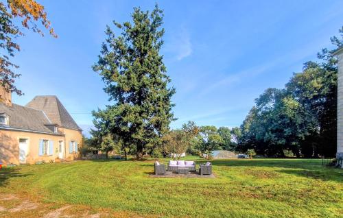 a park with a bench in front of a house at Gite Avec Piscine in Parennes