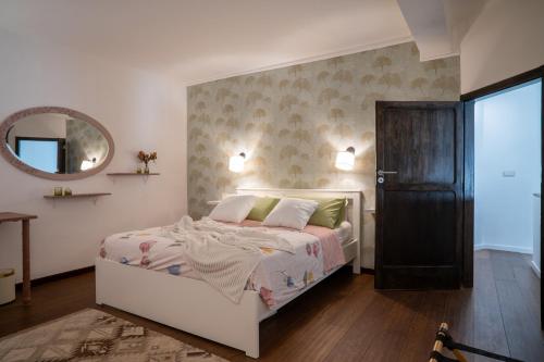 une chambre avec un lit blanc et un miroir dans l'établissement Casa Gianna Holiday Home, à Rutigliano