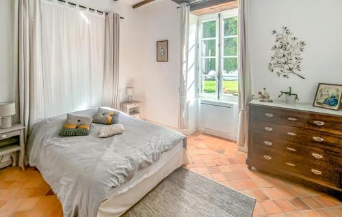 a bedroom with a bed and a dresser and a window at Gite Avec Piscine in Parennes