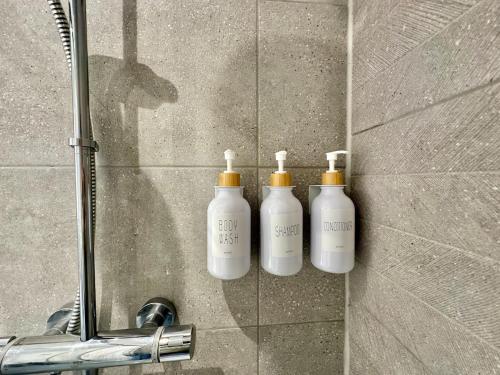 a group of three shampoo bottles on the wall of a shower at The Nest at Heaton Family Friendly Near Preston and Blackpool Ample Parking and WiFi in Kirkham