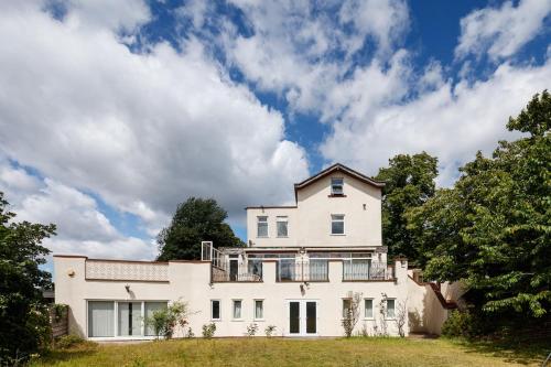 a large white house on a hill with trees at Beautiful 'Mayfield' Villa with private pool! in Manchester