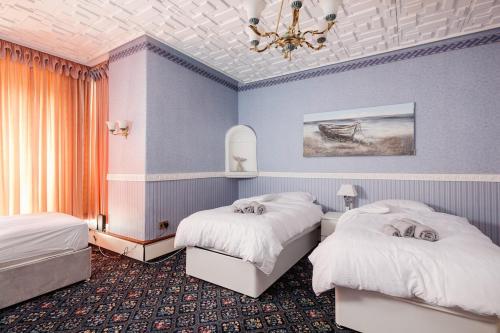 a hotel room with two beds and a chandelier at Beautiful 'Mayfield' Villa with private pool! in Manchester