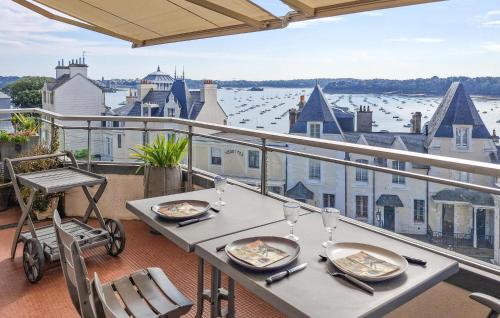 a table on a balcony with a view of the water at Gorgeous Apartment In Dinard With House Sea View in Dinard