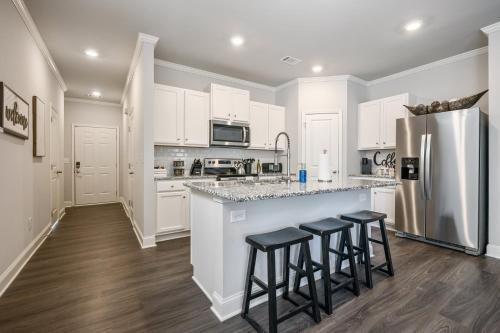 a kitchen with white cabinets and a counter with stools at 2059 Pinnacle Walk Drive Norcross in Norcross