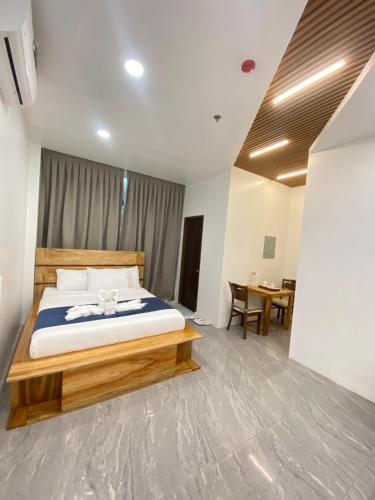 a bedroom with a large bed and a table at AC Cosy Hotel in Lala