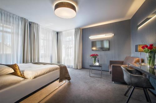a hotel room with a bed and a desk at Hotel Mucha in Prague