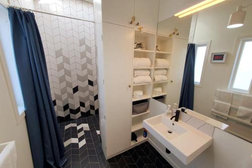 a white bathroom with a sink and a shower at The Cottage on the Olive Grove in Russell