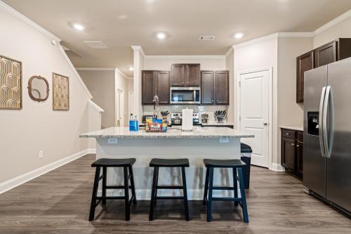 a kitchen with a large island with two bar stools at 2029 Pinnacle Walk Drive Norcross in Norcross