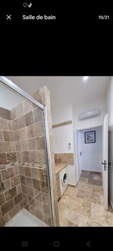 a bathroom with a walk in shower and a washing machine at T3 de 60 M2 avec parking à 3 min de l autoroute in Giroussens