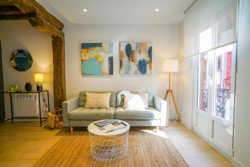 a living room with a couch and a table at Homely Rooms in Santander