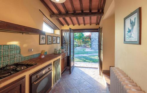 d'une cuisine avec cuisinière et d'une porte donnant sur une cour. dans l'établissement Amazing Apartment In Casole D'elsa With Swimming Pool, à Gallena