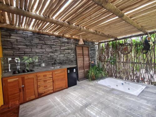 福廷Chalé Jacuzzi的厨房里有浴缸和石墙
