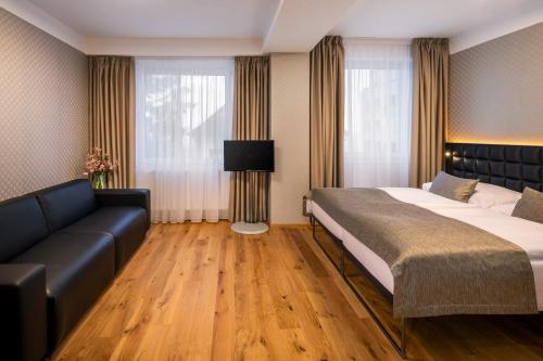 a bedroom with a large bed and a couch at Hotel Aida in Prague